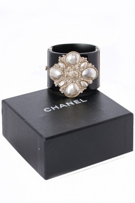 Lot 11 - A Chanel black resin cuff bracelet, 'Coco Rock'...