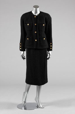 Lot 86 - A Chanel black boucle tweed suit, 1980s,...