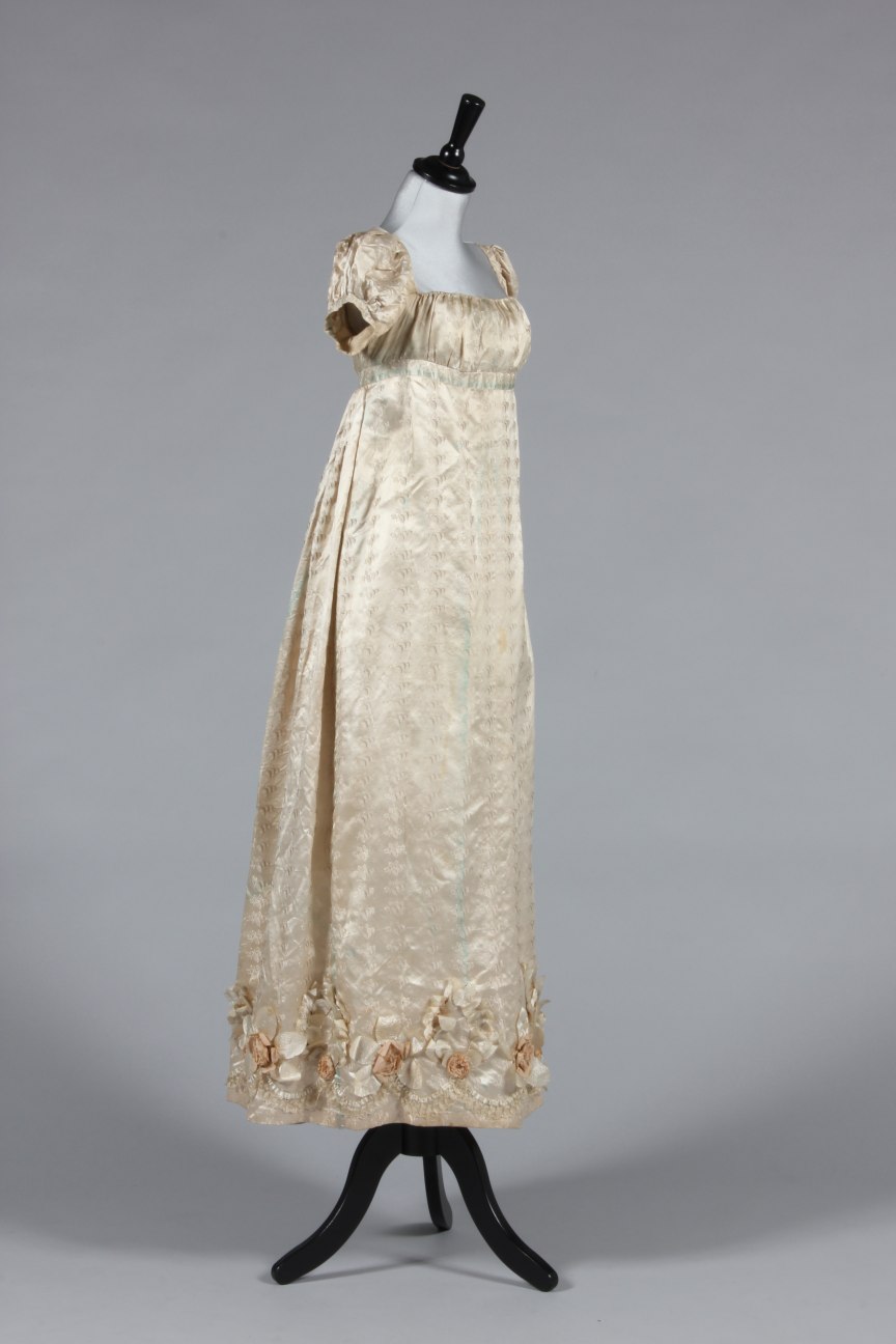 Lot 422 - An ivory figured silk gown circa 1815-20,