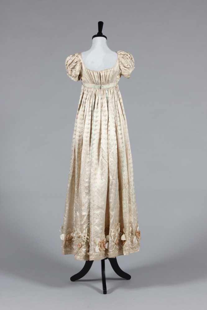 Lot 422 - An ivory figured silk gown circa 1815-20,