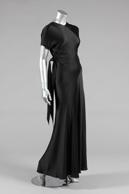 Lot 429 - A slinky black bias-cut satin evening gown, a...