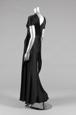 Lot 429 - A slinky black bias-cut satin evening gown, a...