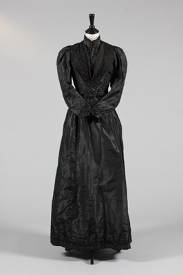 Lot 127 - A black silk taffeta gown, late 1890s, with...