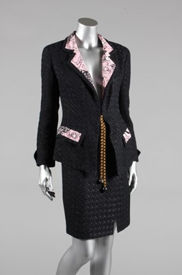 Lot 92 - A Chanel black wool and pink printed silk suit,...