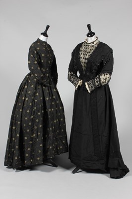 Lot 119 - A black and gold figured silk gown, circa 1865,...