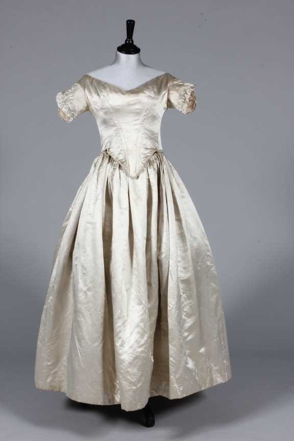 Lot 50 - An ivory satin bridal gown, circa 1845, with