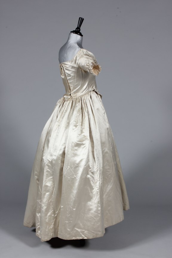 Lot 50 - An ivory satin bridal gown, circa 1845, with