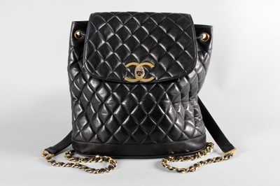 Lot 4 - A Chanel quilted black leather duffle bag,...