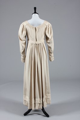 Lot 76 - An oyster-pink figured silk gown, circa 1815,...