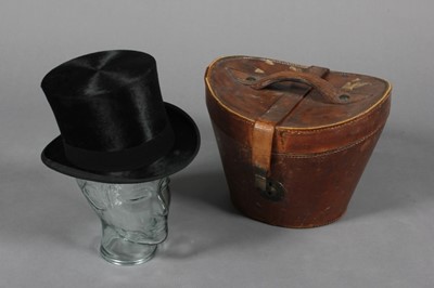 Lot 68 - A top hat in 19th century leather case, the...