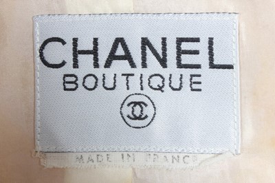 Lot 207 - A Chanel pink tweed suit, 1980s, boutique...