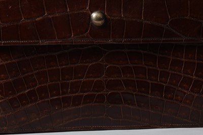 Lot 18 - A Cartier dark brown crocodile clutch bag,...