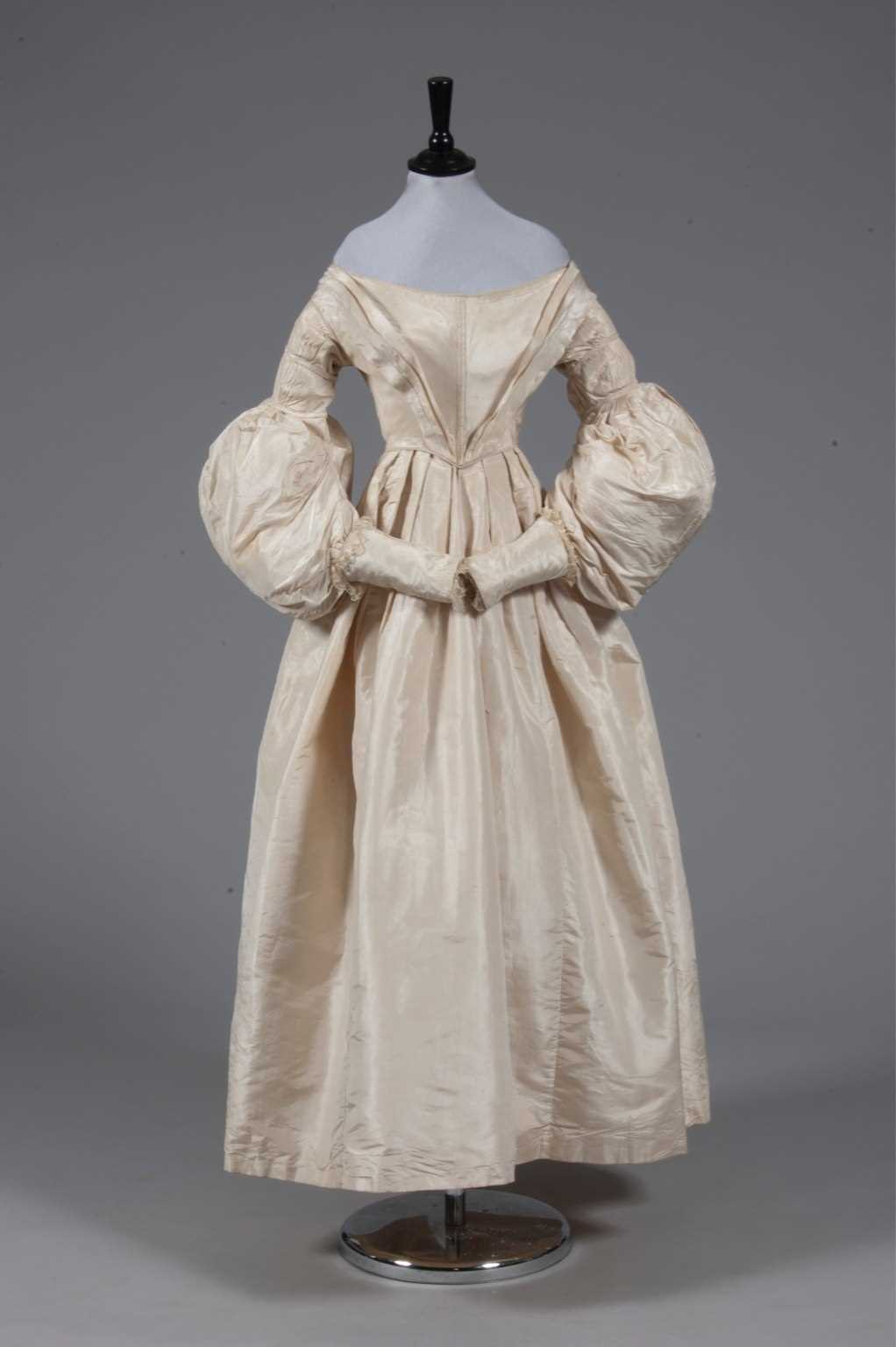 Lot 56 - An ivory silk bridal gown, circa 1838, with...