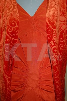 Lot 207 - A brick red crepe de chine evening gown, circa...