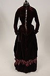 Lot 98 - An aubergine velvet walking dress, circa 1880,...
