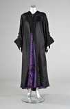 Lot 99 - A dramatic black satin opera coat, circa 1900,...