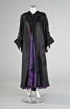Lot 99 - A dramatic black satin opera coat, circa 1900,...