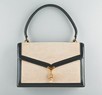 Lot 12 - An Hermès tan canvas and black leather handbag,...