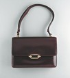 Lot 18 - An Hermès burgundy leather handbag, circa 1960,...