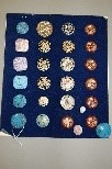 Lot 245 - A display board and loose of enamelled buttons,...