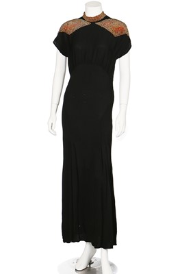 Lot 71 - A black crêpe evening-gown with studded red and purple angular insertions to shoulders, mid 1940s