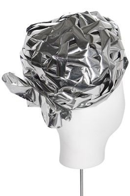 Lot 143 - A futuristic Dior hat of woven silver cellophane-ribbon over a tulle ground, circa 1965