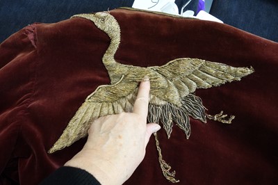 Lot 237 - A burgundy velvet robe appliquéd with large gilt-thread embroidered cranes amongst lily pads, Japanese, probably 1910s