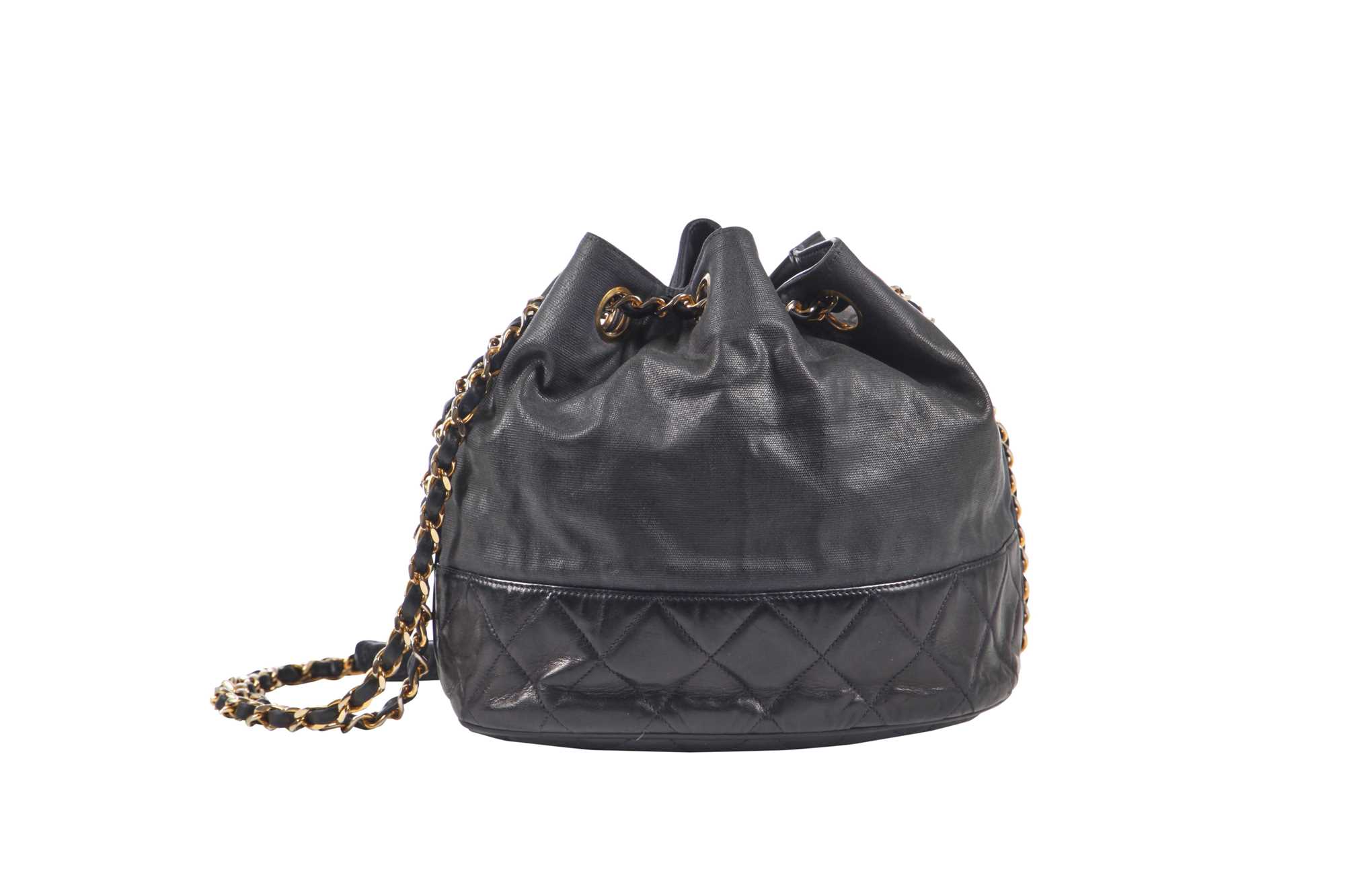Lot 14 - A Chanel waxed canvas and navy quilted leather bucket bag, 1986-1988