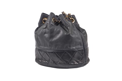 Lot 14 - A Chanel waxed canvas and navy quilted leather bucket bag, 1986-1988
