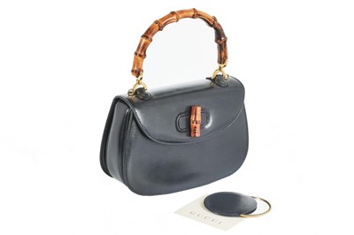 Lot 101 - A Gucci navy leather handbag with bamboo...