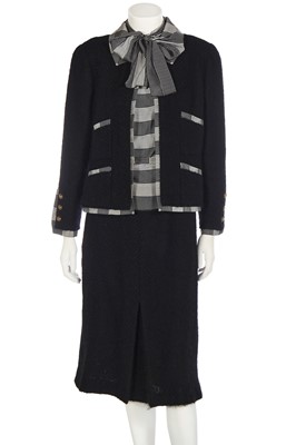 Lot 27 - A Chanel black tweed and silk trimmed suit, 1980s
