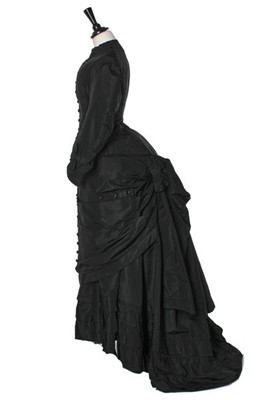 Lot 282 - A black faille mourning gown, late 1870s,...