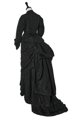 Lot 282 - A black faille mourning gown, late 1870s,...