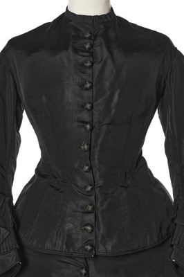 Lot 282 - A black faille mourning gown, late 1870s,...