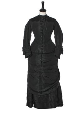 Lot 282 - A black faille mourning gown, late 1870s,...