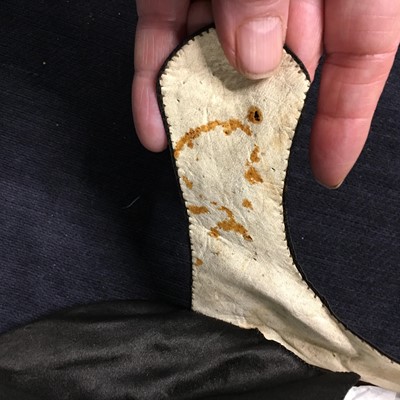 Lot 423 - A pair of black satin shoes and a pair of unusual brown leather pattens, 1770-1780