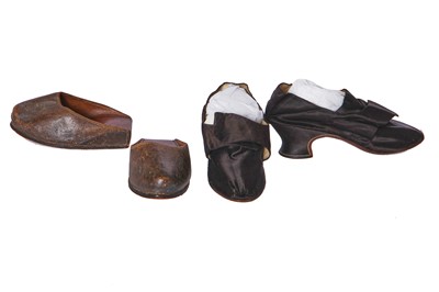 Lot 423 - A pair of black satin shoes and a pair of unusual brown leather pattens, 1770-1780