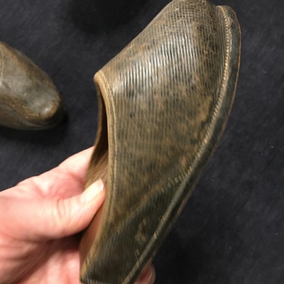 Lot 423 - A pair of black satin shoes and a pair of unusual brown leather pattens, 1770-1780