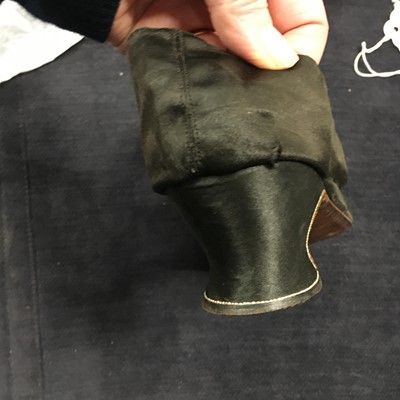 Lot 423 - A pair of black satin shoes and a pair of unusual brown leather pattens, 1770-1780