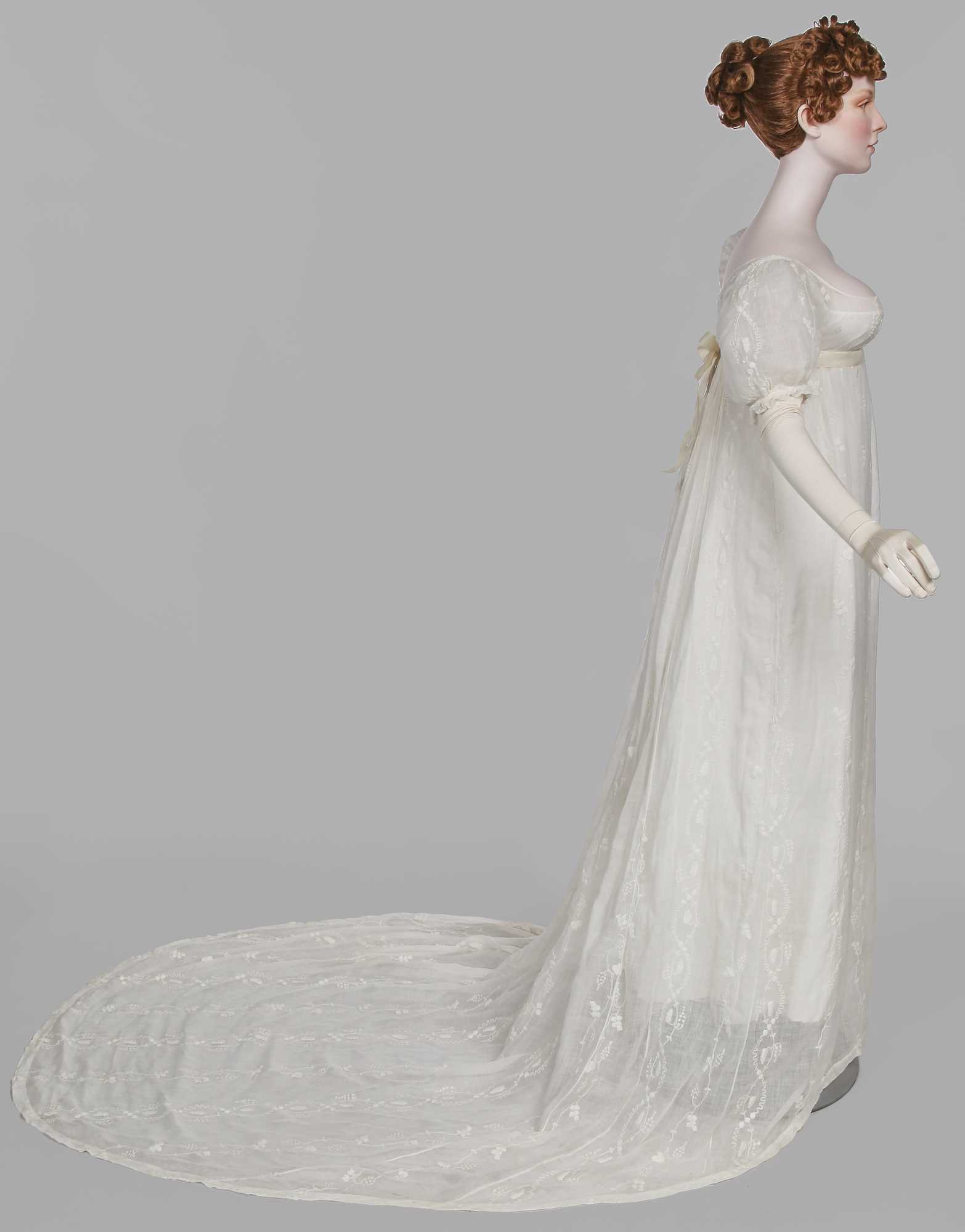 Click for high resolution Lot 34 - A whitework embroidered muslin evening gown with long trained hem, French, 1800-04