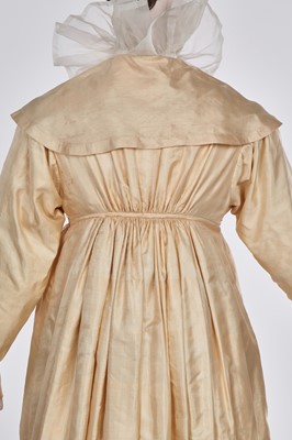 Lot 111 - A pale apricot sarsanet redingote/pelisse, French, circa 1815