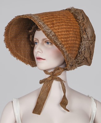 Lot 107 - A rare woven wood and striped cotton bonnet, circa 1806