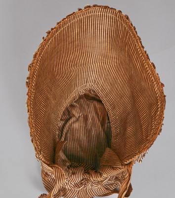 Lot 107 - A rare woven wood and striped cotton bonnet, circa 1806