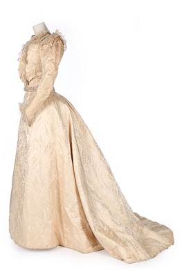 Lot 392 - An ivory damask silk bridal gown, circa 1890,...