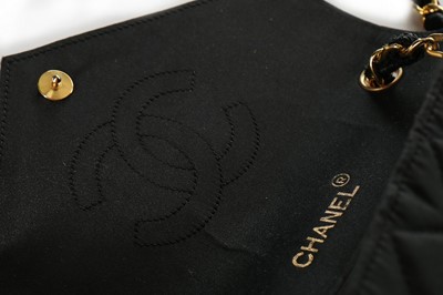 Lot 121 - A Chanel black satin quilted evening bag with...