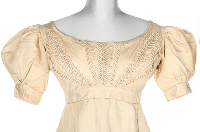 Lot 250 - An ivory silk evening dress, circa 1820,...