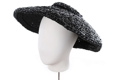 Lot 214 - A Balenciaga woven raffia hat, circa 1950,...