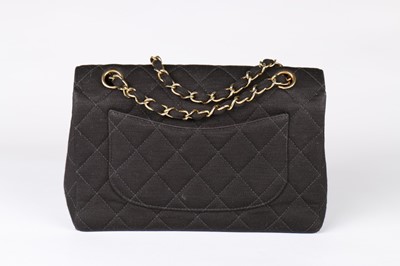 Lot 8 - A Chanel black quilted jersey handbag, 1980s,...