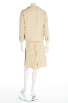 Lot 157 - A Chanel couture ivory tweed suit, 1964, broad...