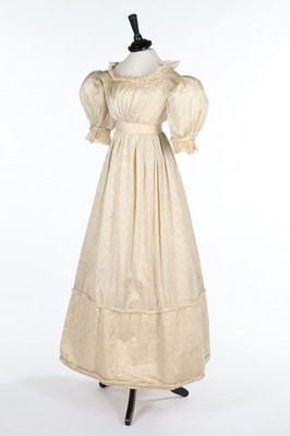Lot 105 - An ivory figured silk gown, 1820s with later...